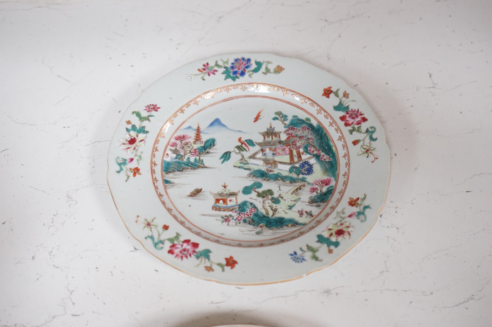 Three Chinese famille rose plates, Qianlong, including an armorial example, largest 22.5cm in diameter